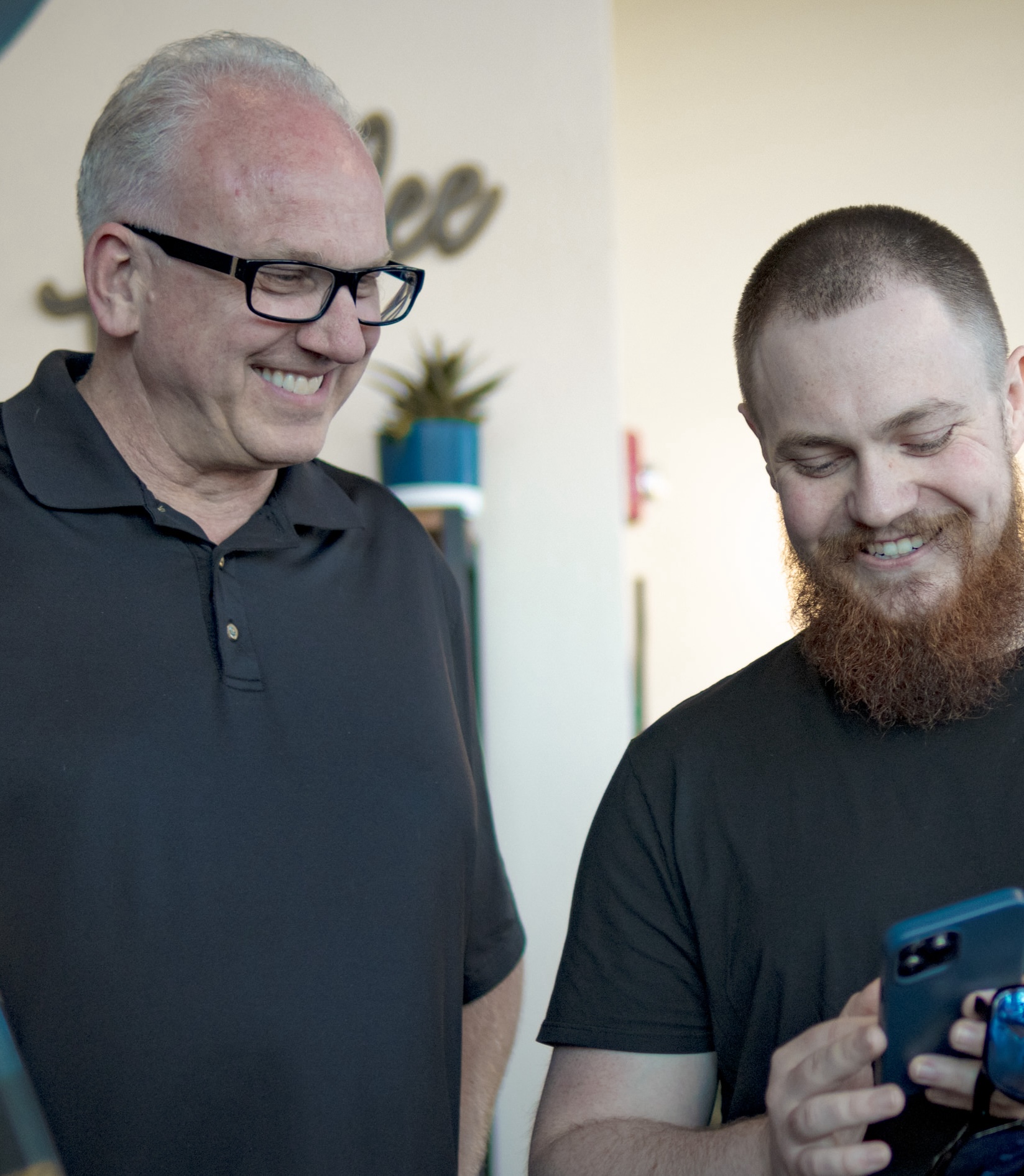 Social media expert and business owner looking at phone and smiling to see their Yakima website design project
