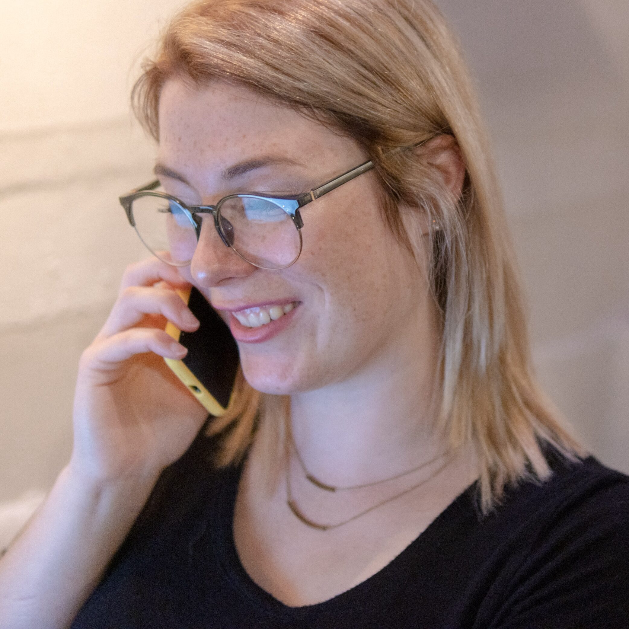 Woman talking on phone smiling and talking with client about their Yakima website design project